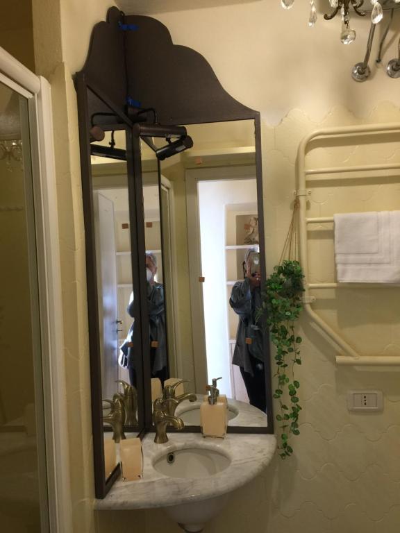 łazienka z umywalką i lustrem w obiekcie Tuscany Heba w mieście Magliano in Toscana