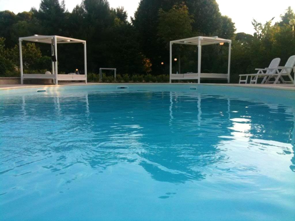 セルヴァ・ディ・ファザーノにある2 bedrooms appartement with shared pool and wifi at Selva di Fasano 9 km away from the beachの青い大型スイミングプール(椅子2脚、ガゼボ付)