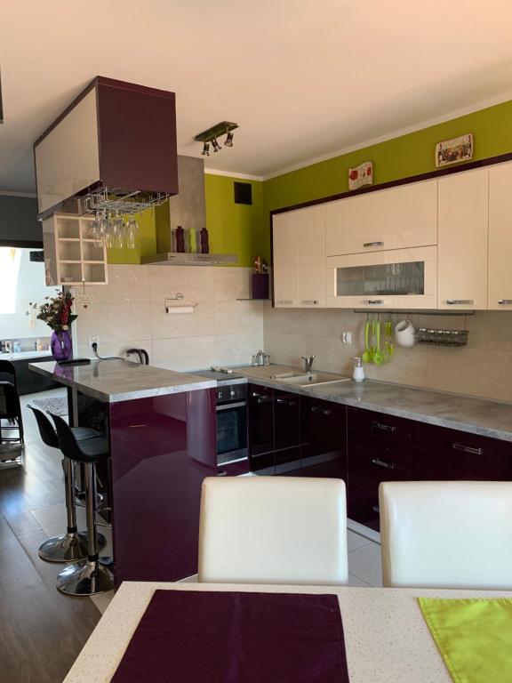 a kitchen with white cabinets and a counter top at Silver Mazury Apartament in Giżycko