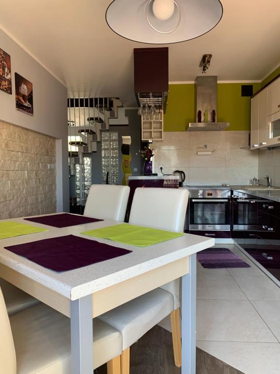 a kitchen with a white table and white chairs at Silver Mazury Apartament in Giżycko