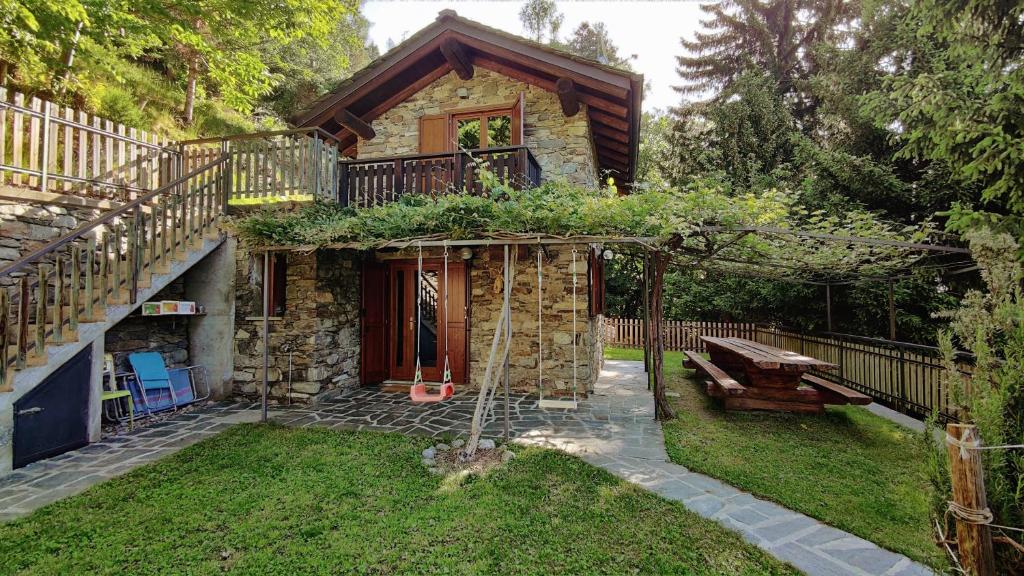 Cette petite maison en pierre dispose d'une terrasse couverte et d'un banc. dans l'établissement Baita Nonna Maria, à Postalesio