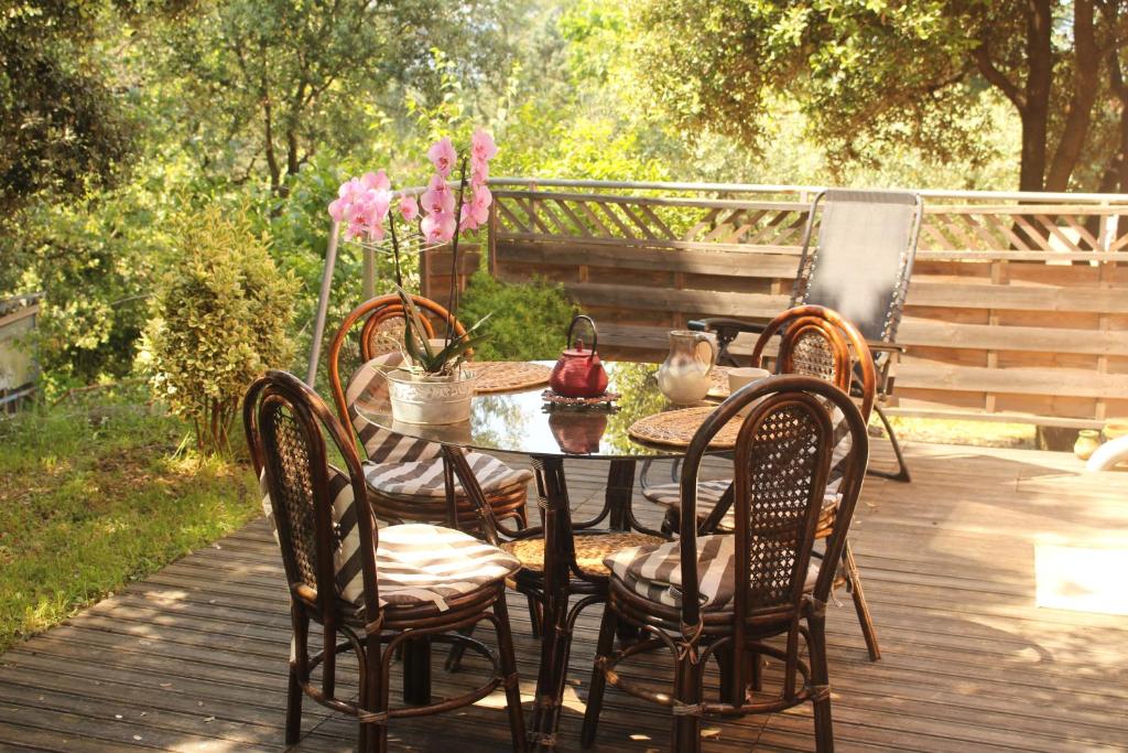une table et des chaises sur une terrasse en bois dans l'établissement La Rousse, à Roussillon
