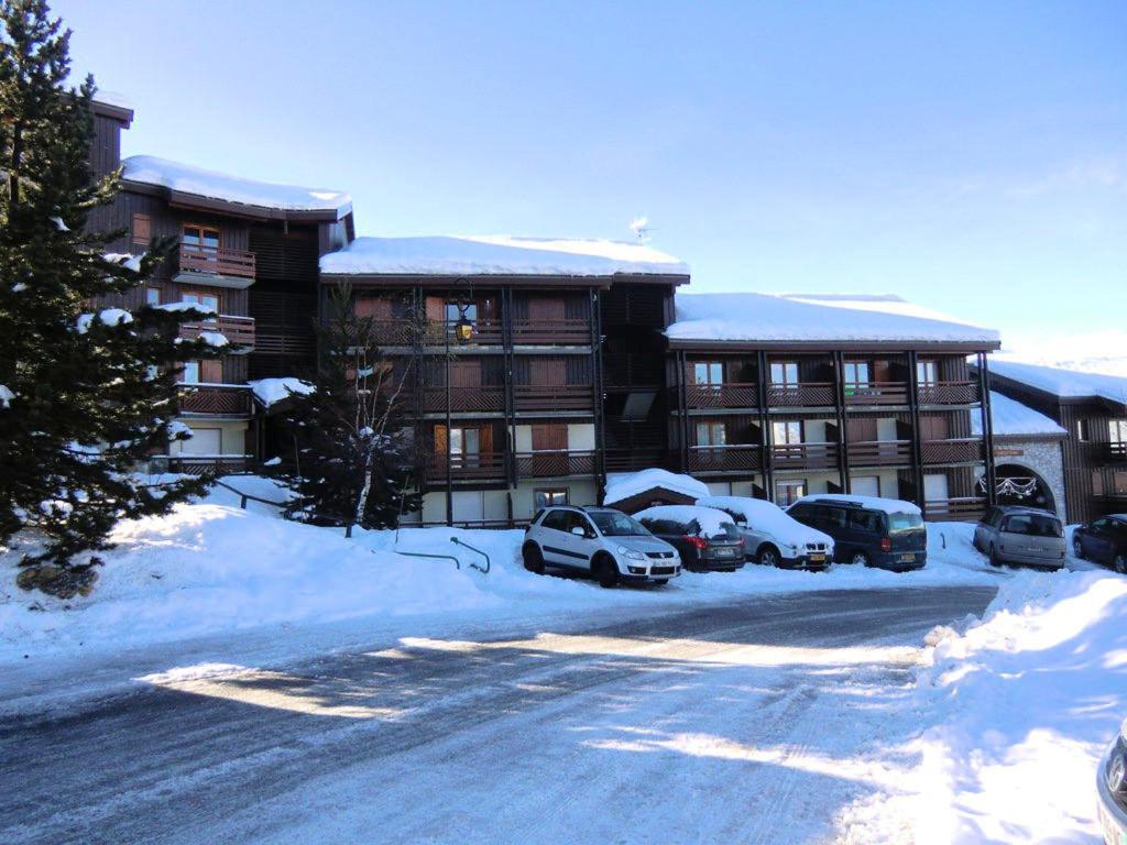 un parking couvert de neige en face d'un hôtel dans l'établissement Appartement de 2 chambres avec terrasse amenagee a La plagne, à La Plagne