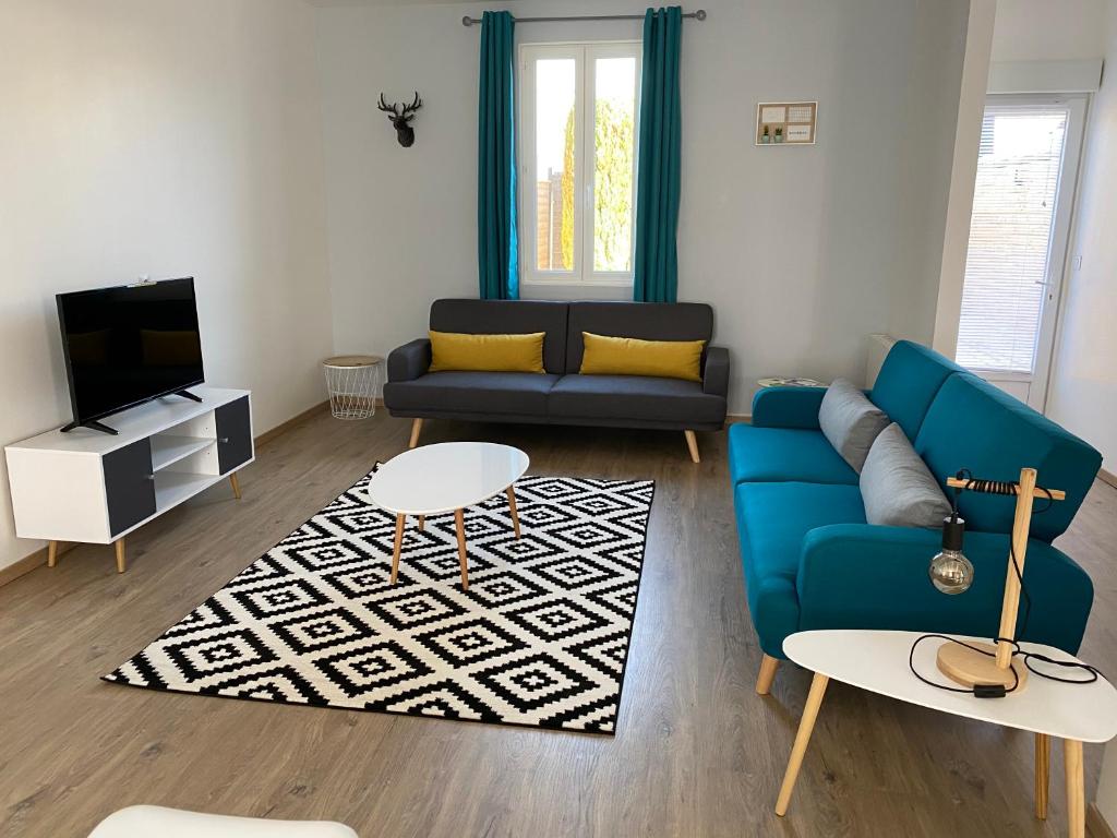 ein Wohnzimmer mit einem blauen Sofa und einem TV in der Unterkunft Family Villa 29 in Le Tréport