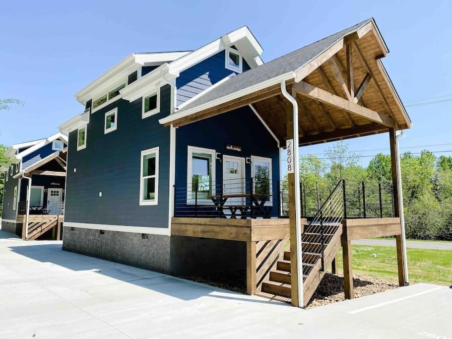 ein Haus mit einer Veranda und einer Terrasse in der Unterkunft Cozy Smoky Mountain Tiny House in Pigeon Forge