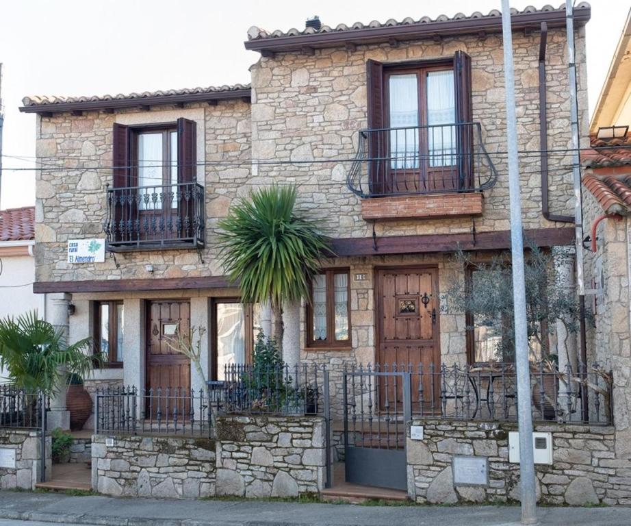 une maison en pierre avec un palmier devant dans l'établissement Casa Rural El Olivo / El Almendro, à Aldeadávila de la Ribera