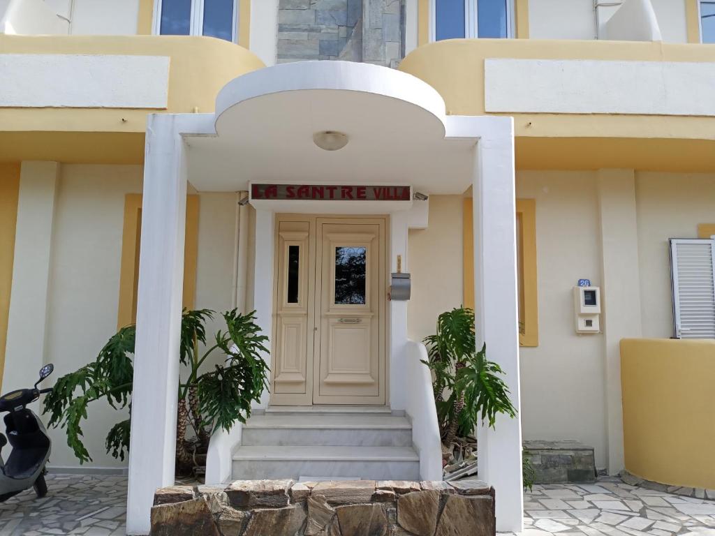 um edifício branco com um sinal por cima da porta em La Santre Villa em Amoudara Herakliou