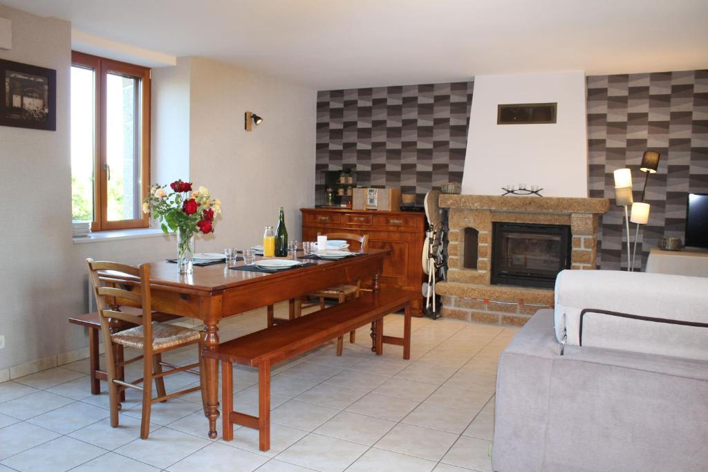 a living room with a table and a fireplace at Gîte La Loussaudrie in Pontmain
