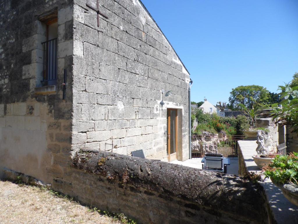 uma parede de tijolos ao lado de um edifício com uma porta em Maisonnette climatisée avec parking privé em Montfort