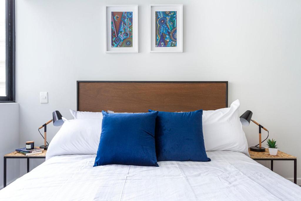 un letto con due cuscini blu sopra di 2BR New apartment next to Roma Norte and Reforma a Città del Messico
