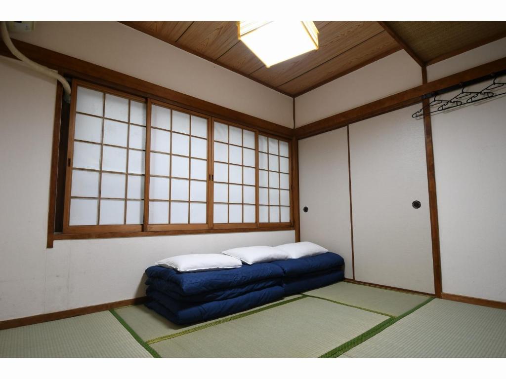 Pokój z niebieskim łóżkiem w pokoju z oknami w obiekcie Onsen Inn Hamayu Nagi - Vacation STAY 81905 w mieście Beppu