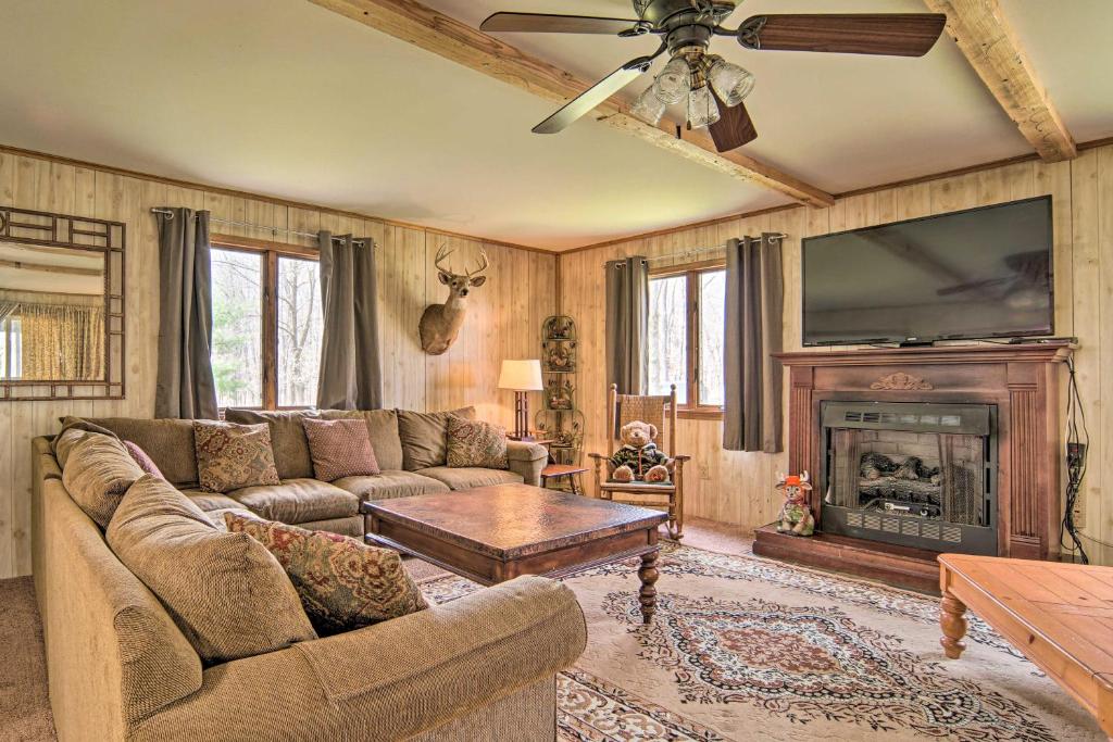 uma sala de estar com um sofá e uma lareira em Rustic and Modern Russell Cabin with Grill and Deck em Russell
