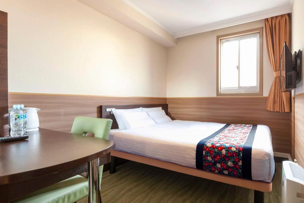 Postel nebo postele na pokoji v ubytování Dotonbori Hotel