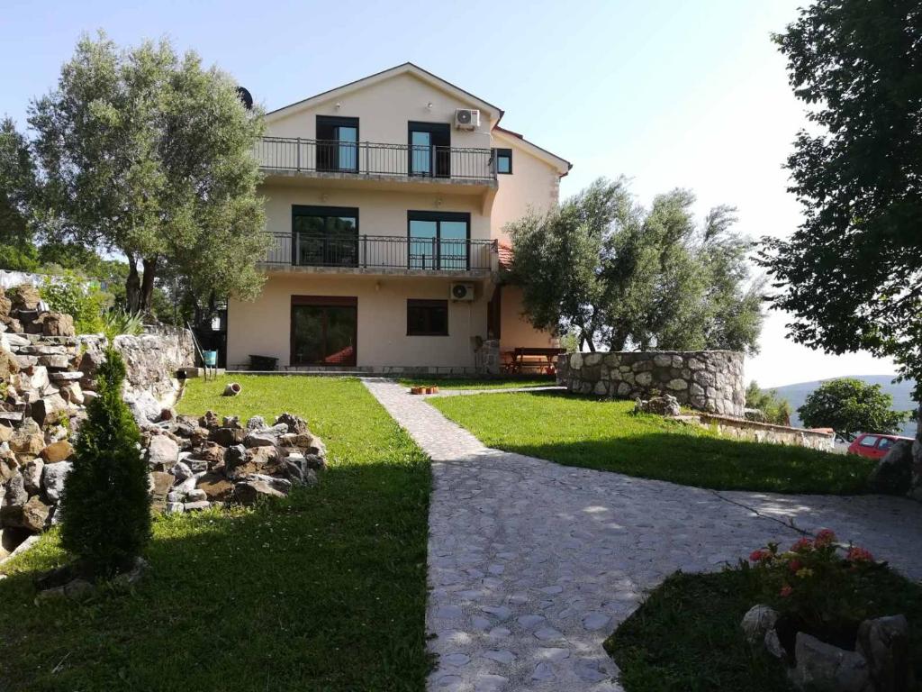 una casa con una pasarela de piedra delante de ella en Forest Apartments, en Kotor