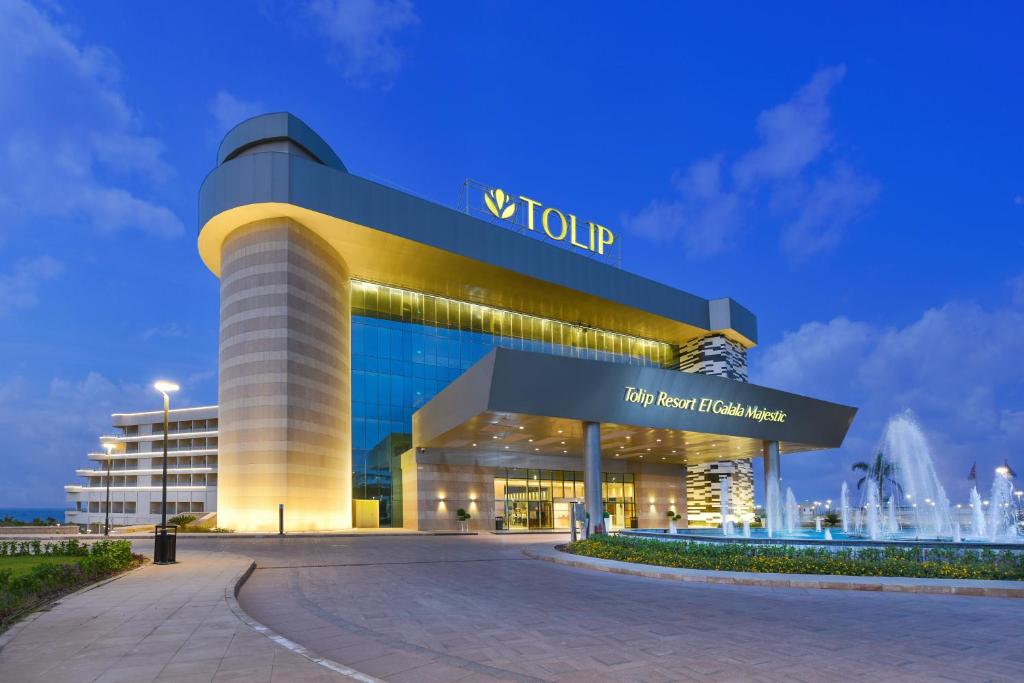 
a large building with a clock on the front of it at Tolip Resort El Galala Majestic in Ain Sokhna

