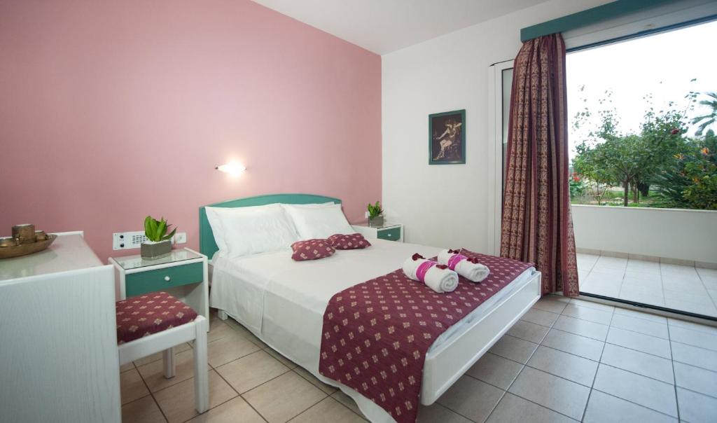 a bedroom with a bed and a window at Theoni Apartments in Malia