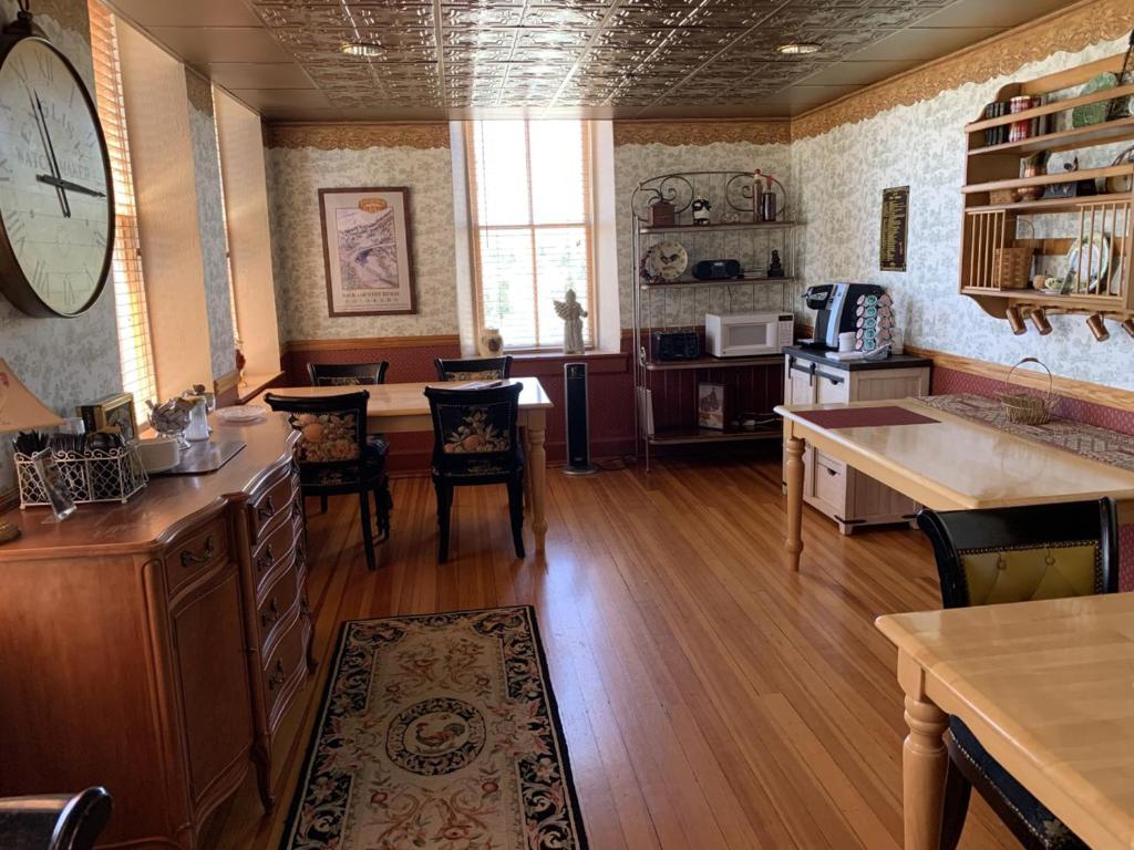 a kitchen with a table and a clock on the wall at Hotel St Nicholas in Cripple Creek