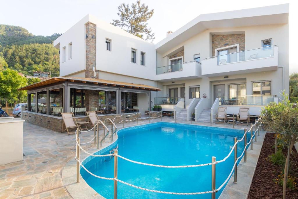 a villa with a swimming pool and a house at Oli Terra in Skala Potamias