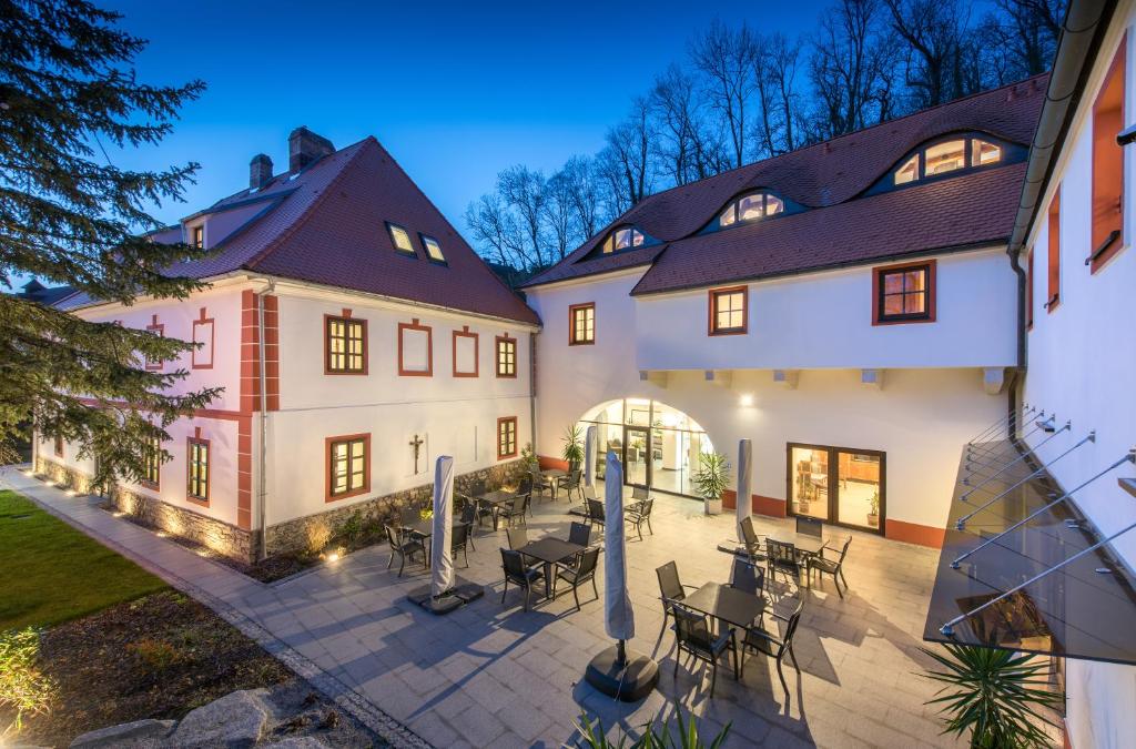 a courtyard in a house with tables and chairs at Residence Hluboká in Hluboká nad Vltavou