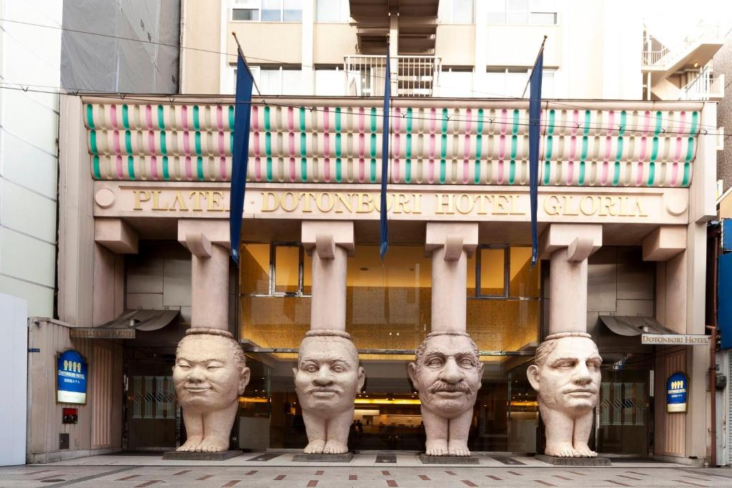 two statues of people are in front of a building at Dotonbori Hotel in Osaka