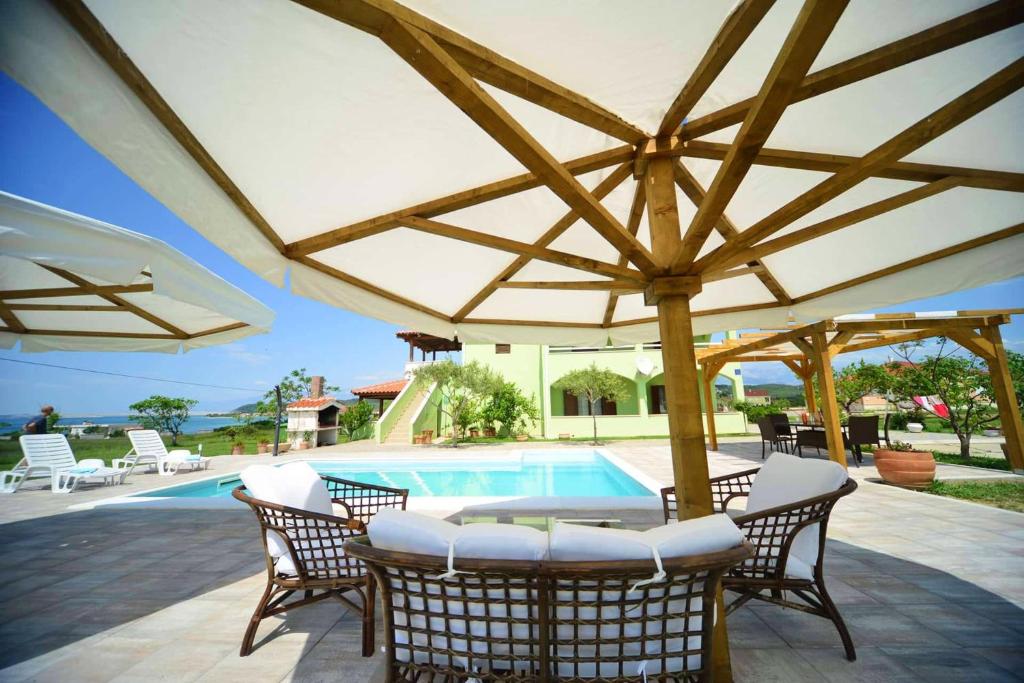 a patio with an umbrella and a swimming pool at Sea View Apartment + Pool, Ljubač, 32 m² in Ljubač
