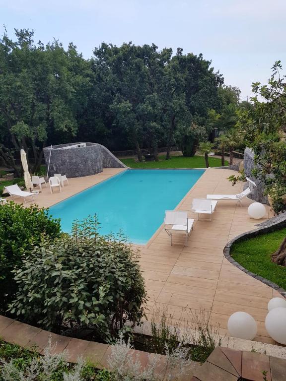 uma grande piscina com espreguiçadeiras num quintal em Studio with shared pool enclosed garden and wifi at Trecastagni 8 km away from the beach em Trecastagni