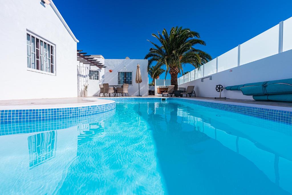 una piscina de agua azul y un edificio blanco en Casa Keiley en Puerto del Carmen