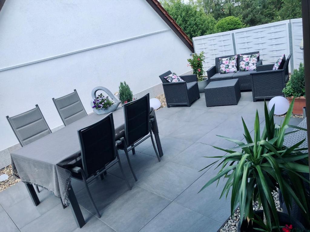 a patio with a table and chairs and plants at Apartment Elegance in Höheischweiler