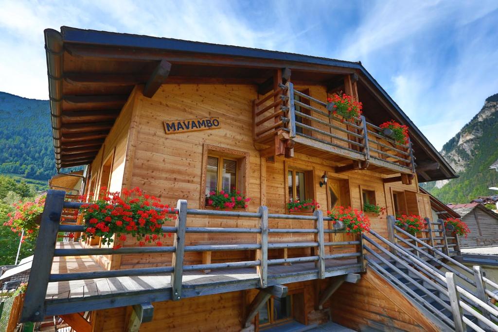 ein Blockhaus mit Blumenkästen auf dem Balkon in der Unterkunft Chalet Mavambo in Le Châble