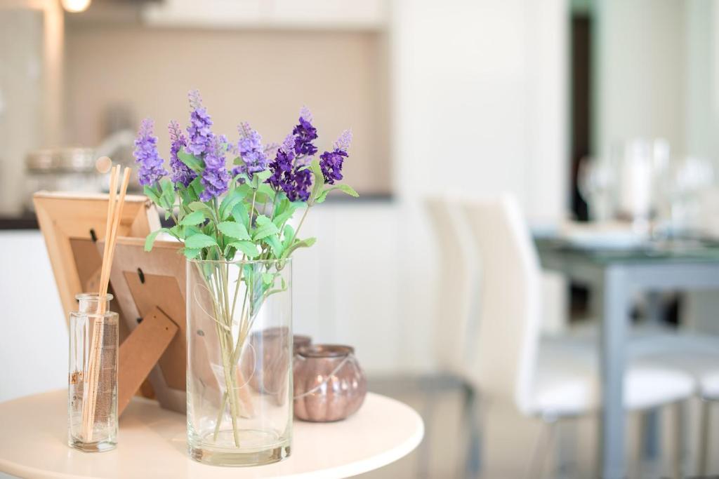 a vase of purple flowers sitting on a table at Lavender Bay Apartment B13 in Donji Morinj
