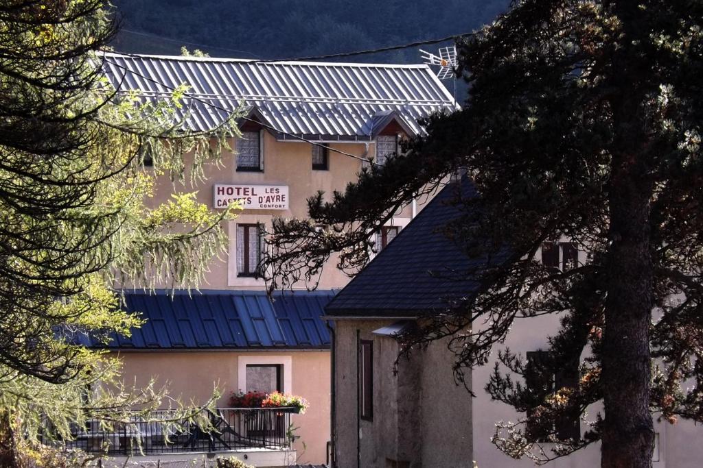 un edificio con techo azul con un cartel. en Hôtel Les Castets d'Ayré en Barèges