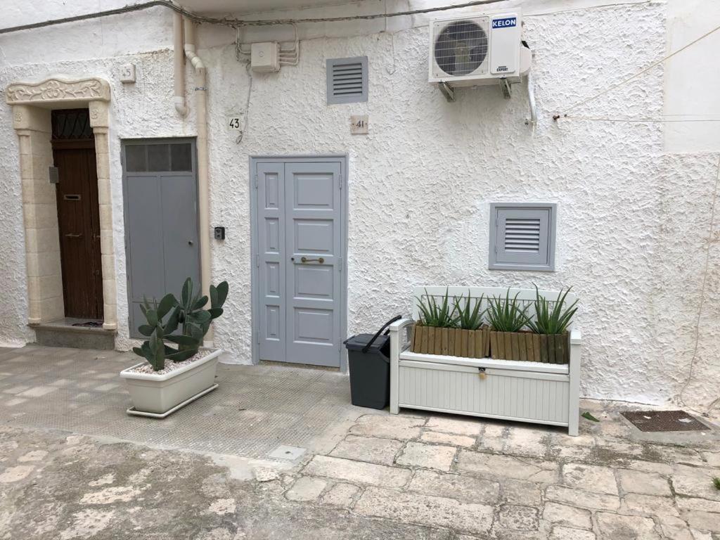 una casa con due piante davanti ad una porta di B&B A Casett a Fasano