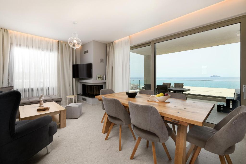 uma sala de estar com uma mesa de jantar e vista para o oceano em Diamond Dream III em Kalamaki