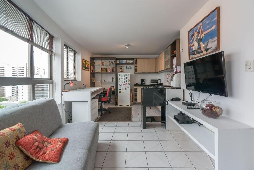 Una sala de estar con un sofá y un escritorio. en Ótimo Flat Bairro da Jaqueira Recife até 3 pessoas O Coração Verde da Cidade PBO902, en Recife