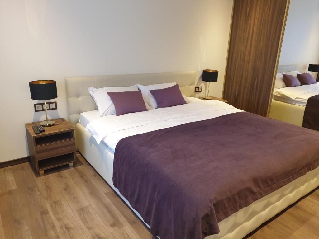 sypialnia z dużym łóżkiem i stolikiem nocnym w obiekcie MARBEO 5 Star Luxury Suites - Siena w mieście Lipawa