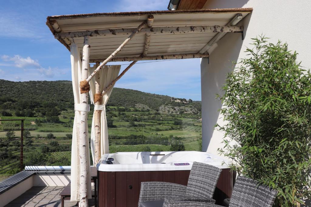 a hot tub on the deck of a house at Gite Aigues Vives in Montpeyroux