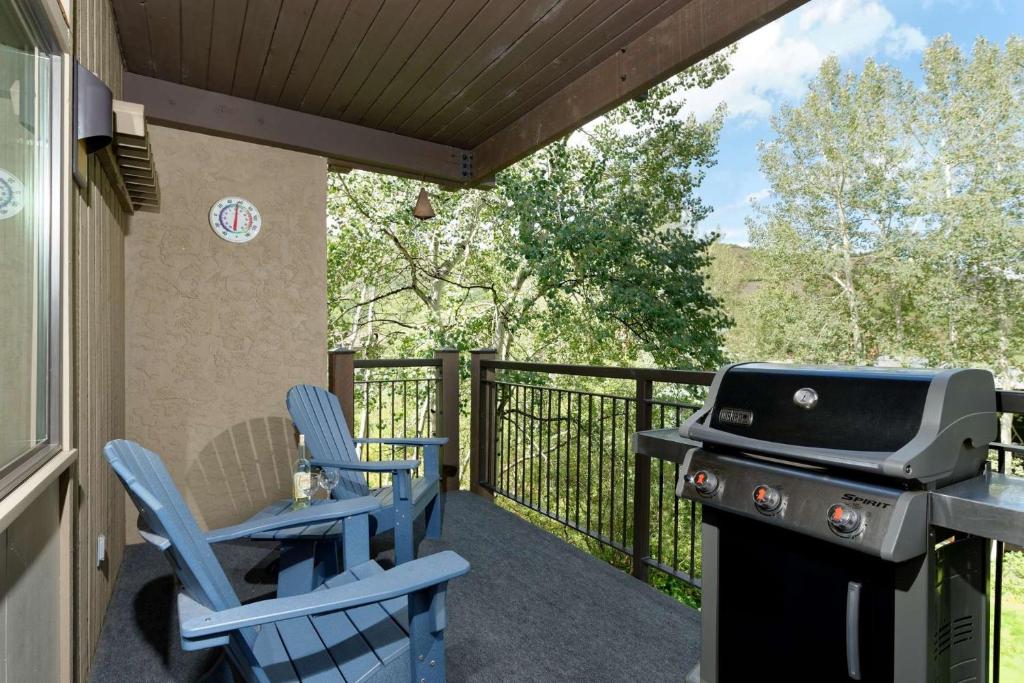 een afgeschermde veranda met stoelen en een grill bij Shadowbrook 104 in Snowmass Village