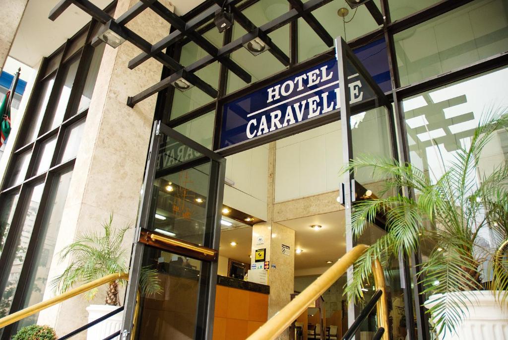 una entrada carnegie de hotel a un edificio con una señal de hotel en Caravelle Palace Hotel, en Curitiba