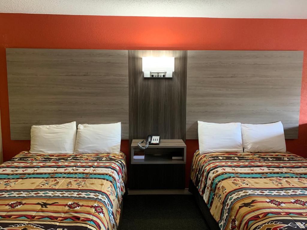 a hotel room with two beds and a table with a phone at Log Cabin Inn in Bay Minette