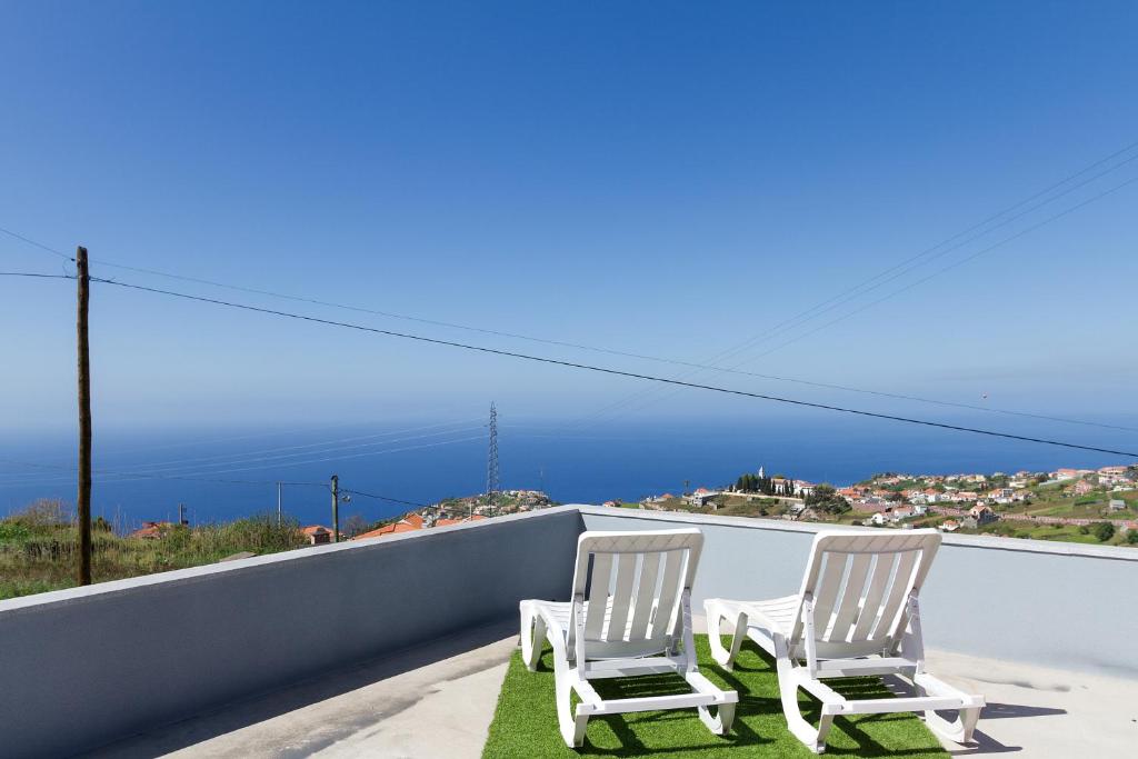 ポンタ・ド・ソルにある2 bedrooms house with sea view furnished terrace and wifi at Ponta do Sol 5 km away from the beachの海の景色を望むバルコニー(椅子2脚付)