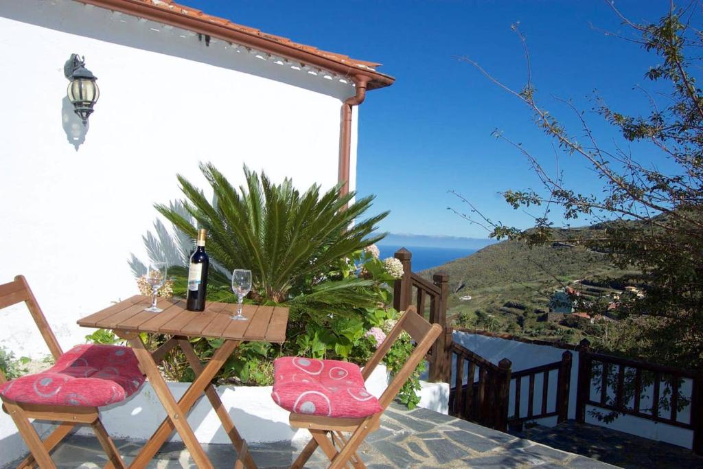 uma mesa com uma garrafa de vinho e duas cadeiras em 2 bedrooms appartement with furnished terrace and wifi at Santa Cruz de Tenerife Canarias 5 km away from the beach em Los Silos