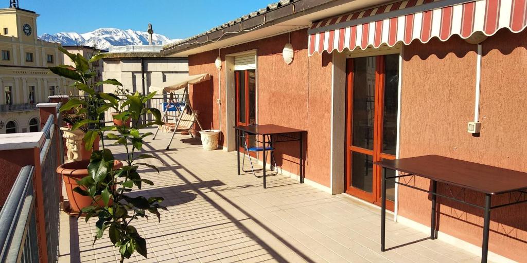 - un balcon avec des bancs et des tables dans un bâtiment dans l'établissement 2 bedrooms appartement with sea view furnished terrace and wifi at Orsogna, à Orsogna