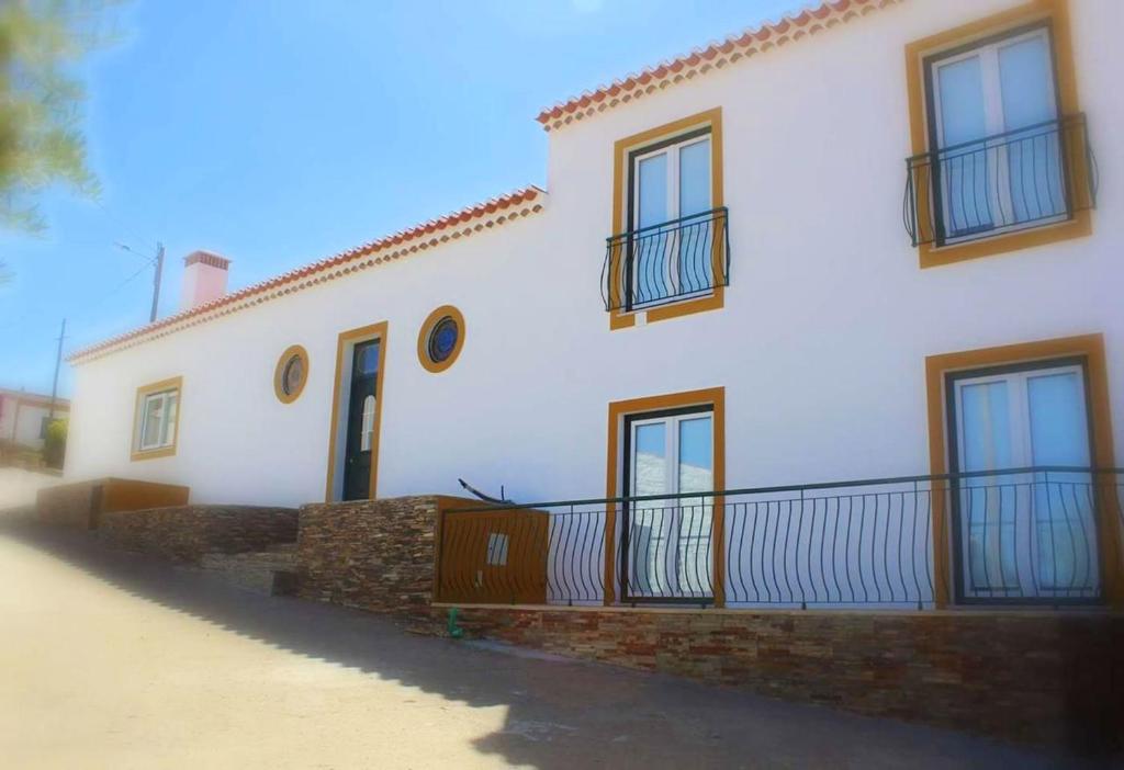 a white house with a balcony on the side of it at 7 bedrooms house with private pool enclosed garden and wifi at Corte de Pao E Agua in Corte de Pão e Água