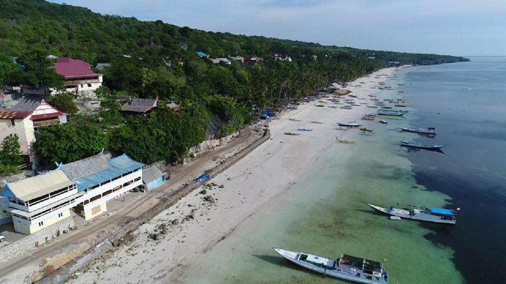 an aerial view of a beach with boats in the water at Phinisi Hostel Bira in Bira