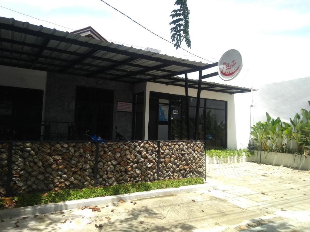 a building with a retaining wall and a fence at skyz hostel in Padang