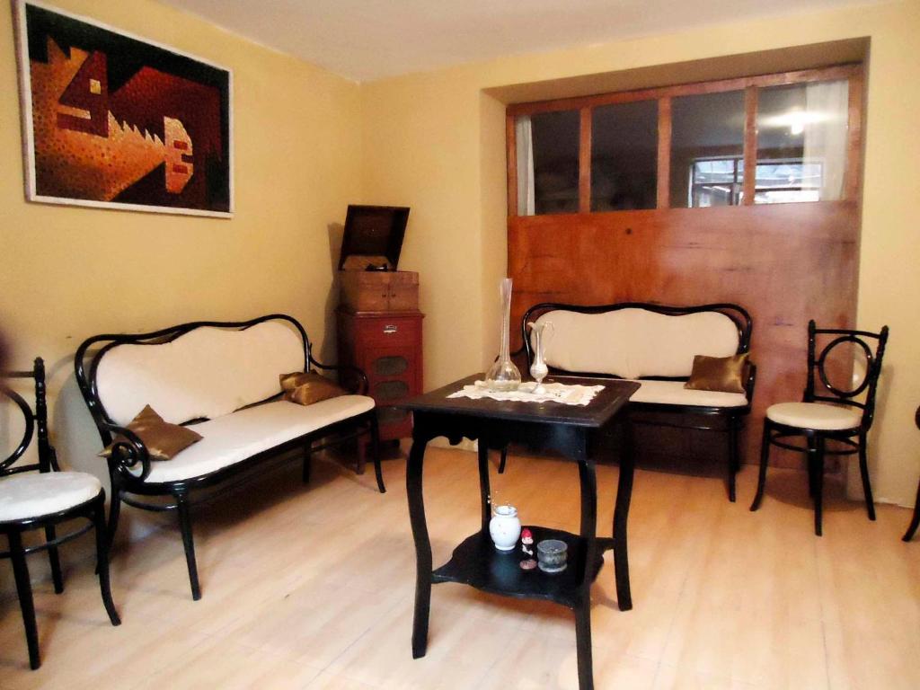 Habitación con 2 sillas, mesa y mesa. en Emperatriz Guest House, en Cusco