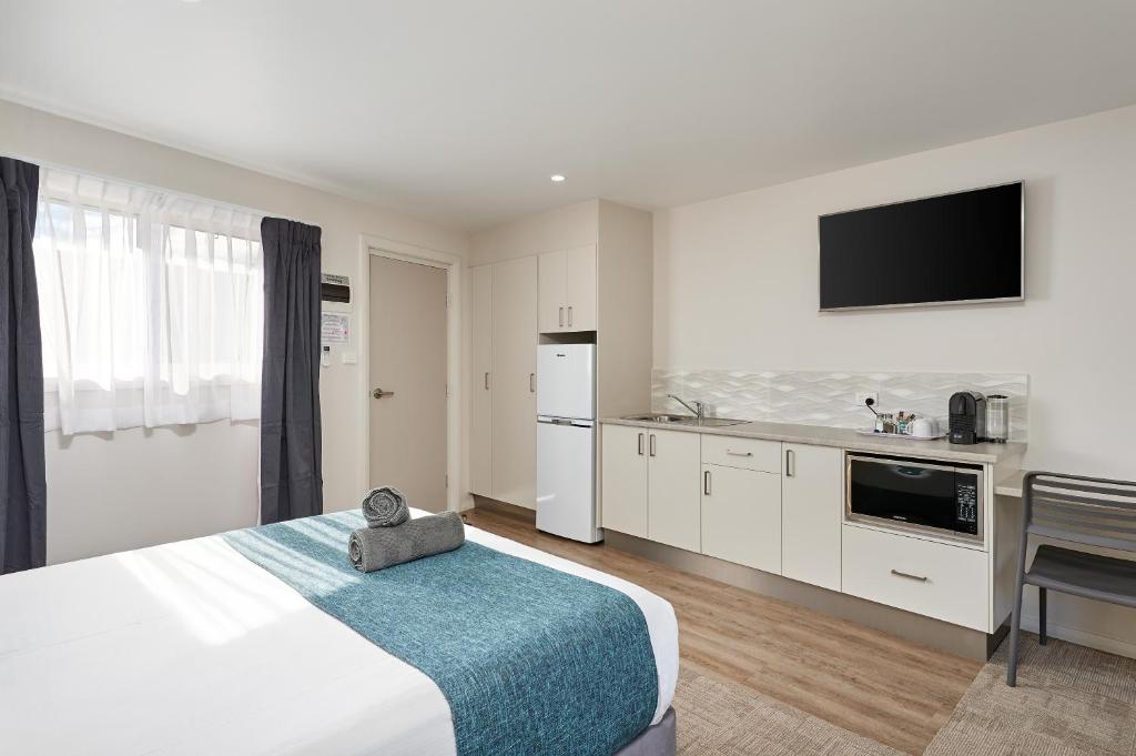 a hotel room with a large bed and a kitchen at Gundagai Tourist Suites in Gundagai