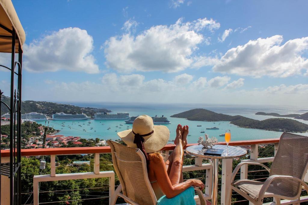 a woman sitting in a chair looking out at the ocean at The Mafolie Hotel in Mafolie