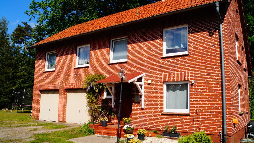 una casa de ladrillo rojo con garaje blanco en Ferienwohnung Familie von Seggern, en Bispingen