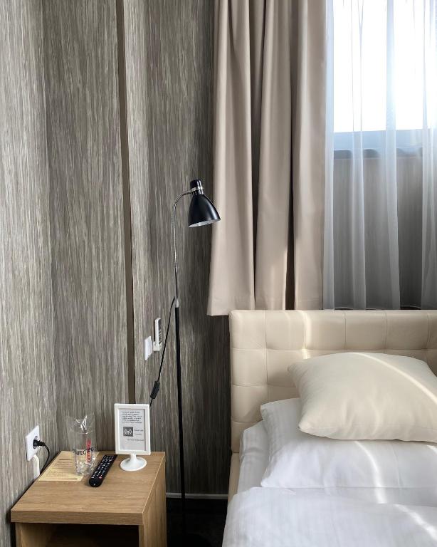 a bedroom with a bed and a table with a lamp at Hotel Banja Luka in Banja Luka
